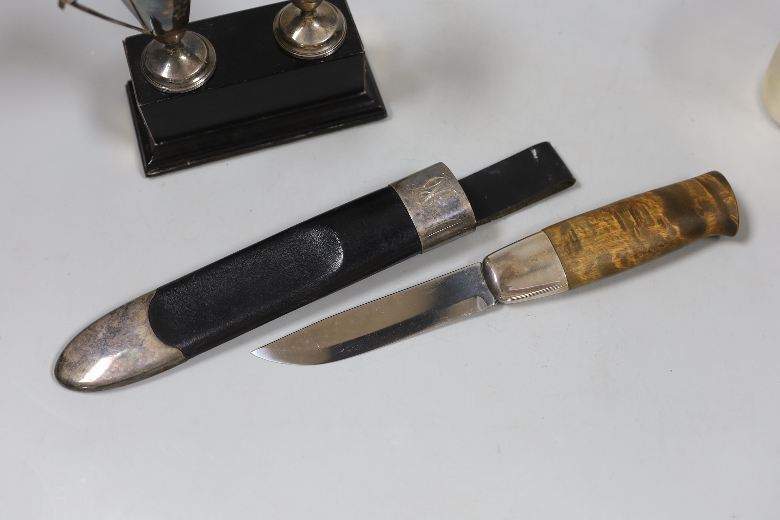 A pair of small silver beakers with gilt interiors and leaded rims, WW, London, 2000, 70mm, two small trophy cups on plinth and a knife in leather scabbard., NB: From the Estate of Rt Hon Lord Lawson of Blaby